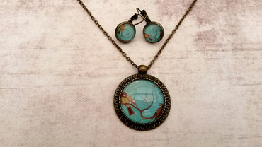 Handgemaakte ketting met bruine vogels op turquoise achtergrond Handgemaakte ketting met bruine vogels op turquoise achtergrond
